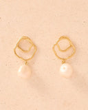 Gold plated abstract circle earrings with dangling natural pearl, combining artistic design with timeless elegance — επιχρυσωμένα σκουλαρίκια με αφηρημένο κυκλικό σχέδιο και κρεμαστό φυσικό μαργαριτάρι, που συνδυάζουν μοντέρνα αισθητική και διαχρονική κομψότητα. Διαθέσιμα στο Iconic Angels Glyfada.