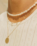 Freshwater pearl choker necklace with delicate gold clasp and adjustable chain, offering timeless elegance and minimal sophistication — choker κολιέ με φυσικά μαργαριτάρια γλυκού νερού και επιχρυσωμένο κούμπωμα με αλυσίδα προσαρμογής, που συνδυάζει διαχρονική κομψότητα και minimal αισθητική. Διαθέσιμο στο Iconic Angels Glyfada.