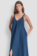 Blue denim-effect maxi dress with thin straps, V-neckline and front slit detail, combining relaxed silhouette with feminine summer elegance — μπλε maxi φόρεμα με denim υφή, λεπτές τιράντες, V ντεκολτέ και μπροστινό σκίσιμο, ιδανικό για island, vacation και casual chic looks. Διαθέσιμο στο Iconic Angels Glyfada.