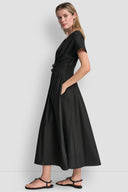 Black midi cotton dress with deep V-neckline, short wide sleeves and structured waist with double buckle belt detail, combining feminine silhouette with modern edge — μαύρο midi φόρεμα με V ντεκολτέ, κοντά φαρδιά μανίκια και ζώνη με διπλή αγκράφα στη μέση, ιδανικό για elegant day to night looks. Διαθέσιμο στο Iconic Angels Glyfada.