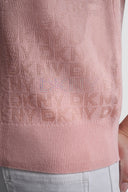 Pink short-sleeve knit polo top with subtle all-over DKNY monogram pattern, V-neckline and classic collar, combining feminine elegance with modern minimal style — ροζ πλεκτό polo top με διακριτικό DKNY monogram, V ντεκολτέ και γιακά, ιδανικό για chic casual και polished day looks. Διαθέσιμο στο Iconic Angels Glyfada.