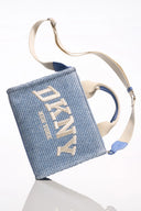 DKNY Hadlee Small Logo Tote σε γαλάζιο ψάθινο σχέδιο με λευκό λογότυπο “DKNY New York”, διπλά κοντά χερούλια και ρυθμιζόμενο λουρί ώμου. Ιδανική καλοκαιρινή tote τσάντα για καθημερινά city looks και resort εμφανίσεις. Διαθέσιμη στο Iconic Angels.