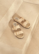 Women’s suede slide sandals in off-white with double buckle straps and espadrille sole, γυναικεία σανδάλια slides από suede δέρμα σε εκρού απόχρωση με διπλή αγκράφα και σχοινένια σόλα, κομψά και άνετα για καλοκαιρινές εμφανίσεις, από το Iconic Angels Glyfada.