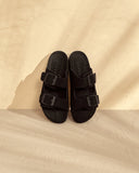 Women’s black suede slide sandals with double buckle straps, γυναικεία σανδάλια slides σε μαύρο χρώμα με διπλή αγκράφα, άνετα και minimal για καθημερινό καλοκαιρινό look, από το Iconic Angels Glyfada.