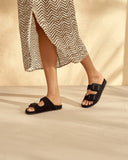 Women’s black suede slide sandals with double buckle straps, γυναικεία σανδάλια slides σε μαύρο χρώμα με διπλή αγκράφα, άνετα και minimal για καθημερινό καλοκαιρινό look, από το Iconic Angels Glyfada.