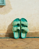 Women’s suede slide sandals in pastel green with double buckle straps, γυναικεία σανδάλια slides από suede δέρμα σε παστέλ πράσινη απόχρωση, άνετα και statement για καλοκαιρινές εμφανίσεις, από το Iconic Angels Glyfada.