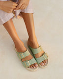 Suede Nordic sandals in soft sage green with adjustable buckles and a natural jute footbed, bringing a fresh, laid-back feel to everyday summer styling — σουέτ Nordic σανδάλια σε απαλό sage green με ρυθμιζόμενες αγκράφες και φυσικό πάτο από σχοινί, ιδανικά για δροσερά και effortless καλοκαιρινά looks από το πρωί έως το βράδυ. Διαθέσιμα στο Iconic Angels Glyfada.