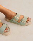 Suede Nordic sandals in soft sage green with adjustable buckles and a natural jute footbed, bringing a fresh, laid-back feel to everyday summer styling — σουέτ Nordic σανδάλια σε απαλό sage green με ρυθμιζόμενες αγκράφες και φυσικό πάτο από σχοινί, ιδανικά για δροσερά και effortless καλοκαιρινά looks από το πρωί έως το βράδυ. Διαθέσιμα στο Iconic Angels Glyfada.
