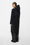 Long black raincoat with glossy marbled effect and relaxed silhouette — μακρύ μαύρο αδιάβροχο με διακριτικό glossy marble εφέ και χαλαρή γραμμή για statement εμφανίσεις ακόμα και τις πιο βροχερές μέρες. Minimal αλλά δυναμικό, φοριέται πάνω από κάθε look και δίνει fashion-forward χαρακτήρα από το πρωί έως το βράδυ. Διαθέσιμο στο Iconic Angels Glyfada.