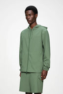 Lightweight green hooded jacket with clean lines and water-resistant finish — ανάλαφρο πράσινο jacket με κουκούλα, minimal αισθητική και αδιάβροχη υφή για προστασία με urban χαρακτήρα. Ιδανικό για layering και effortless street looks, από το πρωινό commute μέχρι τις βραδινές εξόδους. Διαθέσιμο στο Iconic Angels Glyfada.