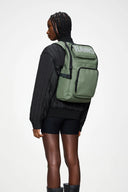 Cargo-style green backpack with bold RAINS logo, multiple zip compartments and structured silhouette, functional and modern for everyday use or travel — πράσινο backpack cargo με έντονο λογότυπο RAINS, πολλαπλές θήκες με φερμουάρ και δομημένο σχήμα, πρακτικό και σύγχρονο για καθημερινές εμφανίσεις ή ταξίδια. Διαθέσιμο στο Iconic Angels Glyfada.
