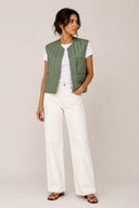 Green quilted liner vest with vertical stitching and front zip closure — πράσινο καπιτονέ γιλέκο με κάθετη ραφή και minimal γραμμή για effortless layering. Ελαφρύ και πρακτικό, φοριέται μόνο του ή κάτω από jacket για extra ζεστασιά και urban χαρακτήρα. Ιδανικό για σύγχρονα, clean looks από το πρωί έως το βράδυ. Διαθέσιμο στο Iconic Angels Glyfada.