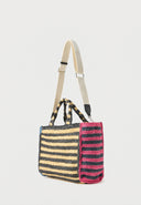 Woven raffia DKNY tote in natural and black stripes with bold pink logo, spacious and lightweight with structured shape — ψάθινη DKNY τσάντα σε ριγέ σχέδιο με έντονο ροζ λογότυπο, ευρύχωρη και καλοκαιρινή, ιδανική για resort looks και city styling με statement χαρακτήρα. Διαθέσιμη στο Iconic Angels Glyfada.