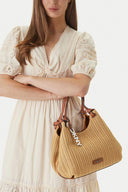 DKNY Paula medium natural woven shoulder bag with raffia-style texture and brown leather straps, featuring a soft curved silhouette and iconic DKNY logo charm for elegant summer everyday outfits — γυναικεία DKNY Paula μεσαία natural woven τσάντα ώμου με ψάθινη υφή και καφέ δερμάτινα λουριά, ιδανική για κομψά καλοκαιρινά και καθημερινά looks.