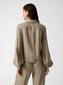 GUESS Dalia Fluid Crop Shirt πράσινο πουκάμισο με relaxed γραμμή, τσέπες στο στήθος και κουμπιά μπροστά, φορεμένο σε total look με παντελόνι, ιδανικό για chic και modern εμφανίσεις.
