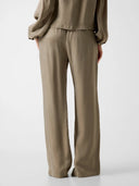 GUESS Dalia Fluid Jogger Pants πράσινο παντελόνι με relaxed γραμμή, ελαστική μέση με κορδόνι και ρευστή υφή, ιδανικό για άνετα και κομψά καθημερινά looks.