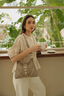 Individual Art Leather Emalene Stone beige τσάντα ώμου από πλεκτό δέρμα με διάτρητο σχέδιο, διακοσμητικό λουράκι με μεταλλικά στοιχεία και ρυθμιζόμενο strap, ιδανική για chic καθημερινά looks.