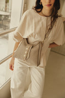 Individual Art Leather Emalene Stone beige τσάντα ώμου από πλεκτό δέρμα με διάτρητο σχέδιο, διακοσμητικό λουράκι με μεταλλικά στοιχεία και ρυθμιζόμενο strap, ιδανική για chic καθημερινά looks.