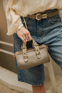 Individual Art Leather Unstoppable Stone beige mini τσάντα ώμου από μαλακό δέρμα με top handle, διακοσμητικά λουράκια και μεταλλικά στοιχεία, ιδανική για elegant και chic καθημερινά looks.