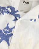 OAS white short sleeve shirt with blue abstract jacquard pattern and camp collar, featuring a relaxed fit and lightweight fabric for summer resort styling — λευκό κοντομάνικο πουκάμισο OAS με μπλε abstract jacquard σχέδιο και camp γιακά, με χαλαρή γραμμή και ελαφρύ ύφασμα για καλοκαιρινά resort looks.