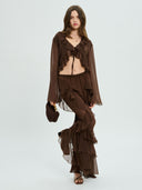 Project Soma brown sheer ruffle pants with layered chiffon detailing and flowing wide-leg silhouette, featuring a high-waisted fit and statement cascading frills for bold evening and fashion-forward looks — γυναικείο Project Soma καφέ διάφανο παντελόνι με βολάν και layered chiffon υφή, σε εντυπωσιακή wide-leg γραμμή για ιδιαίτερα βραδινά looks.