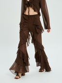 Project Soma brown sheer ruffle pants with layered chiffon detailing and flowing wide-leg silhouette, featuring a high-waisted fit and statement cascading frills for bold evening and fashion-forward looks — γυναικείο Project Soma καφέ διάφανο παντελόνι με βολάν και layered chiffon υφή, σε εντυπωσιακή wide-leg γραμμή για ιδιαίτερα βραδινά looks.