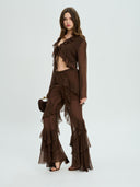 Project Soma brown sheer ruffle pants with layered chiffon detailing and flowing wide-leg silhouette, featuring a high-waisted fit and statement cascading frills for bold evening and fashion-forward looks — γυναικείο Project Soma καφέ διάφανο παντελόνι με βολάν και layered chiffon υφή, σε εντυπωσιακή wide-leg γραμμή για ιδιαίτερα βραδινά looks.