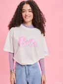 White oversized Barbie logo T-shirt from Project Soma x Barbie collection with pink graphic print for playful casual styling — λευκό γυναικείο oversized t-shirt Project Soma x Barbie με ροζ Barbie logo print για μοντέρνα casual looks. Διαθέσιμο στο Iconic Angels Glyfada.