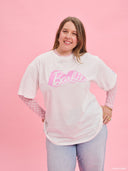 White oversized Barbie logo T-shirt from Project Soma x Barbie collection with pink graphic print for playful casual styling — λευκό γυναικείο oversized t-shirt Project Soma x Barbie με ροζ Barbie logo print για μοντέρνα casual looks. Διαθέσιμο στο Iconic Angels Glyfada.