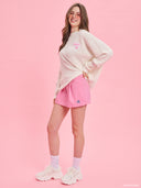 Off-white oversized knit sweater from Project Soma x Barbie collection with embroidered Barbie logo and relaxed silhouette for cozy modern styling — εκρού oversized πλεκτό γυναικείο πουλόβερ Project Soma x Barbie με κεντημένο Barbie logo και άνετη γραμμή για μοντέρνα casual looks. Διαθέσιμο στο Iconic Angels Glyfada.