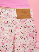 Pink floral ruffle skort from Project Soma x Barbie collection with asymmetric draped detail and playful silhouette for statement summer styling — ροζ floral γυναικείο skort Project Soma x Barbie με ασύμμετρο ruffle και ανάλαφρη γραμμή για εντυπωσιακά summer looks. Διαθέσιμο στο Iconic Angels Glyfada.