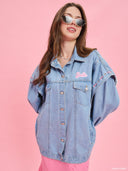 Oversized light blue denim jacket from Project Soma x Barbie collection with pink embroidered Barbie logo and statement streetwear aesthetic — oversized γυναικείο τζιν jacket σε ανοιχτό μπλε από τη συλλογή Project Soma x Barbie, με ροζ κεντημένο Barbie logo και μοντέρνο streetwear χαρακτήρα. Διαθέσιμο στο Iconic Angels Glyfada.