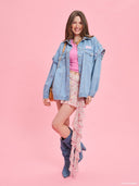 Oversized light blue denim jacket from Project Soma x Barbie collection with pink embroidered Barbie logo and statement streetwear aesthetic — oversized γυναικείο τζιν jacket σε ανοιχτό μπλε από τη συλλογή Project Soma x Barbie, με ροζ κεντημένο Barbie logo και μοντέρνο streetwear χαρακτήρα. Διαθέσιμο στο Iconic Angels Glyfada.