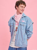 Oversized light blue denim jacket from Project Soma x Barbie collection with pink embroidered Barbie logo and statement streetwear aesthetic — oversized γυναικείο τζιν jacket σε ανοιχτό μπλε από τη συλλογή Project Soma x Barbie, με ροζ κεντημένο Barbie logo και μοντέρνο streetwear χαρακτήρα. Διαθέσιμο στο Iconic Angels Glyfada.