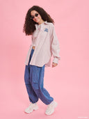 Striped oversized shirt from Project Soma x Barbie collection with pastel stripes and embroidered logo for playful contemporary styling — γυναικείο ριγέ oversized πουκάμισο από τη συλλογή Project Soma x Barbie με pastel ρίγες και κεντημένο logo για μοντέρνα playful looks. Διαθέσιμο στο Iconic Angels Glyfada.