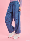 Blue denim balloon pants from Project Soma x Barbie collection with elastic waist and relaxed streetwear silhouette — γυναικείο denim παντελόνι balloon από τη συλλογή Project Soma x Barbie με λάστιχο στη μέση και χαλαρή streetwear γραμμή για statement casual looks. Διαθέσιμο στο Iconic Angels Glyfada.