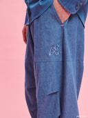 Blue denim balloon pants from Project Soma x Barbie collection with elastic waist and relaxed streetwear silhouette — γυναικείο denim παντελόνι balloon από τη συλλογή Project Soma x Barbie με λάστιχο στη μέση και χαλαρή streetwear γραμμή για statement casual looks. Διαθέσιμο στο Iconic Angels Glyfada.