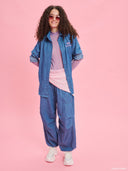 Blue denim balloon pants from Project Soma x Barbie collection with elastic waist and relaxed streetwear silhouette — γυναικείο denim παντελόνι balloon από τη συλλογή Project Soma x Barbie με λάστιχο στη μέση και χαλαρή streetwear γραμμή για statement casual looks. Διαθέσιμο στο Iconic Angels Glyfada.