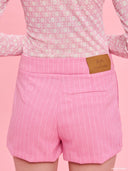 Pink pinstripe tailored shorts from Project Soma x Barbie collection with embroidered logo and structured silhouette for playful chic styling — ροζ ριγέ γυναικείο σορτς Project Soma x Barbie με κεντημένο logo και tailored γραμμή για μοντέρνα summer looks. Διαθέσιμο στο Iconic Angels Glyfada.
