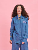 Denim shirt from Project Soma x Barbie collection with embroidered Barbie logo and relaxed contemporary fit — γυναικείο τζιν πουκάμισο από τη συλλογή Project Soma x Barbie με κεντημένο Barbie logo και χαλαρή μοντέρνα γραμμή για statement casual looks. Διαθέσιμο στο Iconic Angels Glyfada.