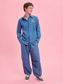 Denim shirt from Project Soma x Barbie collection with embroidered Barbie logo and relaxed contemporary fit — γυναικείο τζιν πουκάμισο από τη συλλογή Project Soma x Barbie με κεντημένο Barbie logo και χαλαρή μοντέρνα γραμμή για statement casual looks. Διαθέσιμο στο Iconic Angels Glyfada.