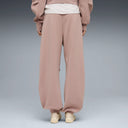 Puma women’s sandstone relaxed sweatpants with elastic waistband and tapered cuffs, offering soft neutral tones and modern athleisure comfort — γυναικείο παντελόνι φόρμας Puma σε απόχρωση sandstone, με λάστιχο στη μέση και tapered τελείωμα, ιδανικό για athleisure και casual chic εμφανίσεις. Διαθέσιμο στο Iconic Angels Glyfada.