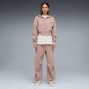 Puma women’s sandstone relaxed sweatpants with elastic waistband and tapered cuffs, offering soft neutral tones and modern athleisure comfort — γυναικείο παντελόνι φόρμας Puma σε απόχρωση sandstone, με λάστιχο στη μέση και tapered τελείωμα, ιδανικό για athleisure και casual chic εμφανίσεις. Διαθέσιμο στο Iconic Angels Glyfada.