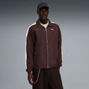 Chocolate brown zip-up track jacket with contrast side stripes and subtle Puma logo detail, combining retro sport heritage with modern street aesthetics — καφέ ανδρικό track jacket με φερμουάρ και λευκές ρίγες στα μανίκια, ιδανικό για athleisure, street style και casual everyday looks με premium χαρακτήρα. Διαθέσιμο στο Iconic Angels Glyfada.