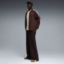Chocolate brown zip-up track jacket with contrast side stripes and subtle Puma logo detail, combining retro sport heritage with modern street aesthetics — καφέ ανδρικό track jacket με φερμουάρ και λευκές ρίγες στα μανίκια, ιδανικό για athleisure, street style και casual everyday looks με premium χαρακτήρα. Διαθέσιμο στο Iconic Angels Glyfada.