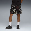 PUMA Sunset Drive relaxed shorts in black with tropical leaf and logo print, featuring a loose fit and lightweight fabric for casual summer wear — ανδρικό σορτς PUMA μαύρο με tropical print φύλλα και logos, σε relaxed γραμμή για άνετα καθημερινά καλοκαιρινά looks.