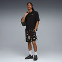 PUMA Sunset Drive relaxed shorts in black with tropical leaf and logo print, featuring a loose fit and lightweight fabric for casual summer wear — ανδρικό σορτς PUMA μαύρο με tropical print φύλλα και logos, σε relaxed γραμμή για άνετα καθημερινά καλοκαιρινά looks.