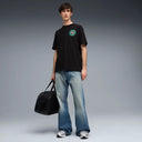 Black graphic t-shirt with front logo detail and bold multicolor Puma artwork on the back, combining streetwear aesthetics with relaxed fit comfort — μαύρο ανδρικό t-shirt με logo print μπροστά και statement πολύχρωμο graphic στην πλάτη, ιδανικό για street style και casual everyday looks με urban χαρακτήρα. Διαθέσιμο στο Iconic Angels Glyfada.