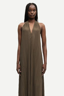 Olive green pleated halter neck maxi dress with fluid silhouette and deep V neckline, creating an elegant elongated shape — χακί maxi φόρεμα με πλισέ υφή και halter λαιμόκοψη, σε αέρινη γραμμή που αγκαλιάζει το σώμα ιδανικό για evening, occasion και refined summer looks με minimal πολυτέλεια. Διαθέσιμο στο Iconic Angels Glyfada.