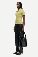 Light olive textured polo top with short sleeves, button placket and fitted silhouette, offering a refined casual feel — λαχανί κοντομάνικο polo top με κουμπιά και ελαστική textured ύφανση, σε εφαρμοστή γραμμή ιδανική για chic casual και modern everyday looks. Διαθέσιμο στο Iconic Angels Glyfada.